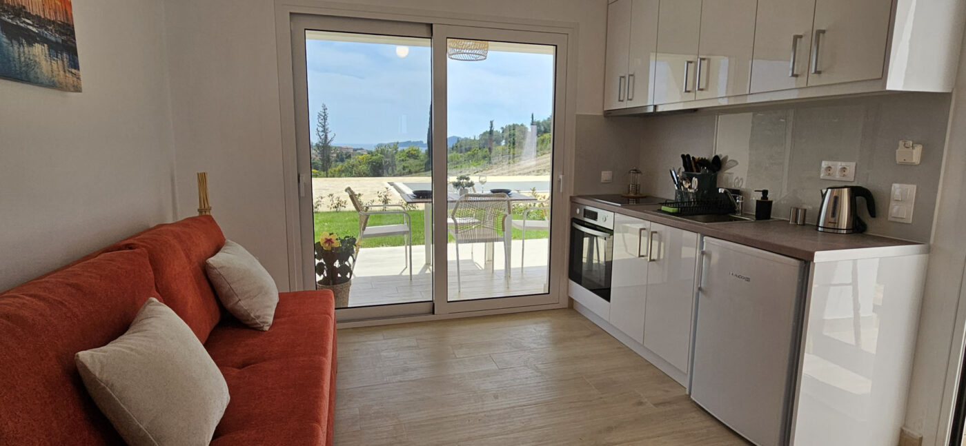 Arillas Peaceful Bungalows Corfu red sofa and kitchen